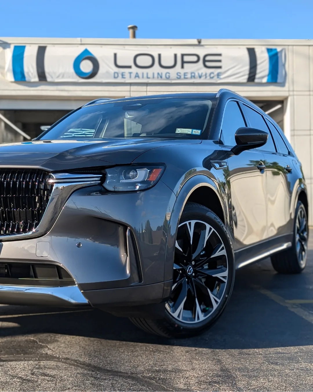 Ceramic coated Mazda SUV parked in front of Loupe Detailing Service shop in Amherst, NY