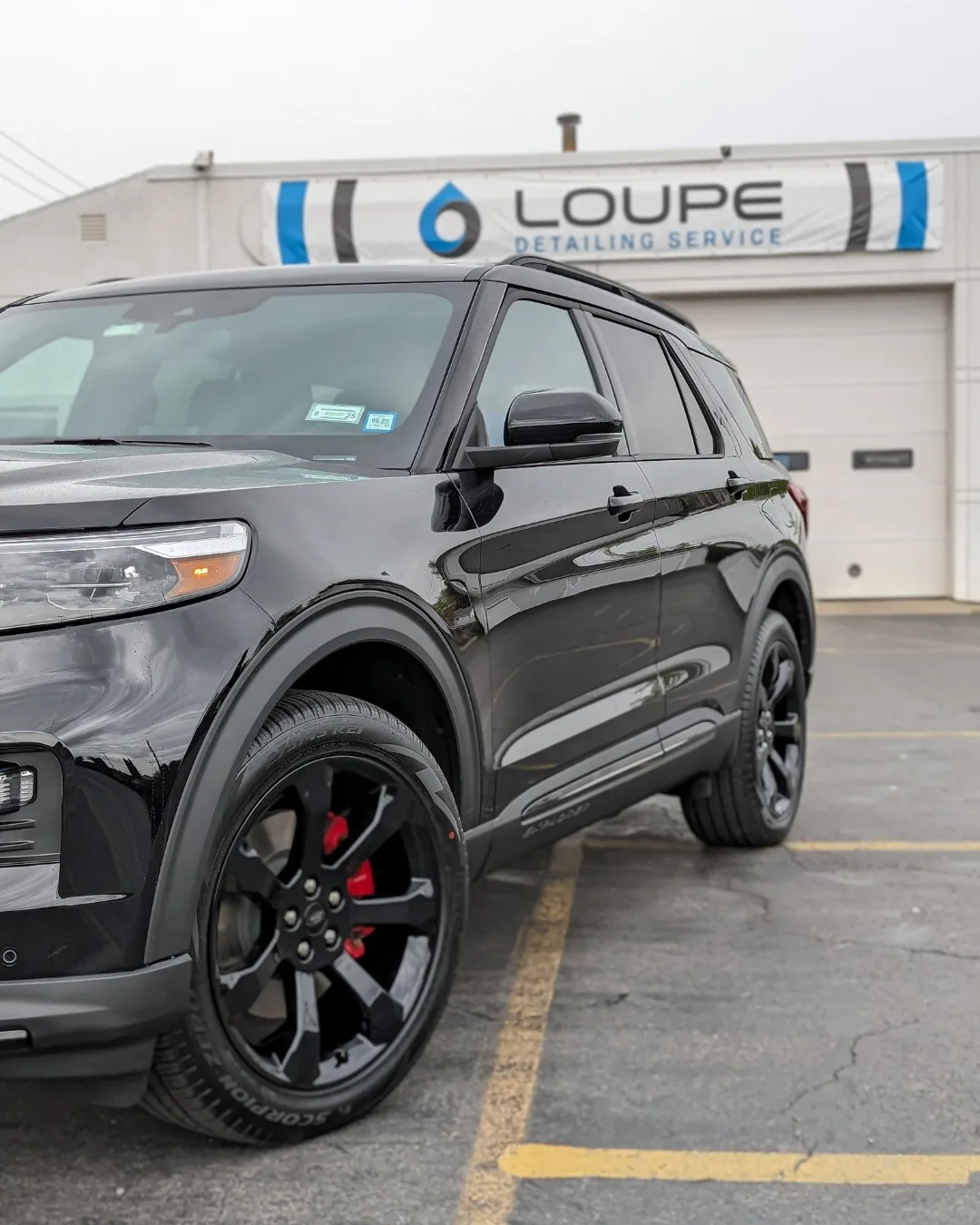 Black Ford Explorer with red calipers after professional detailing and ceramic coating at Loupe Detailing in Amherst, NY